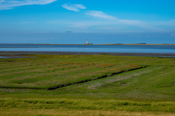 Fototapeta na wymiar Landschaft mit Leuchtturm an der Nordsee
