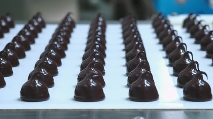 Chocolate candy bars production - food industry process. A lot of chocolates on the production line.