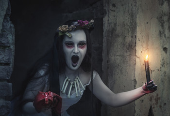 Creepy dead bride with candle screaming. Halloween scene