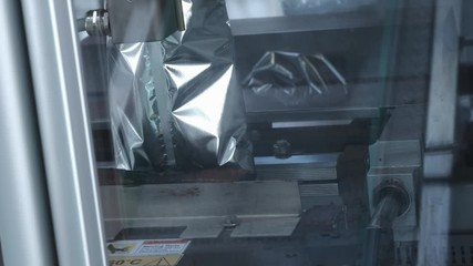 Packs sweets on a production line. Modern Thermo-packaging. Parcel trailer unloading to conveyor belt system