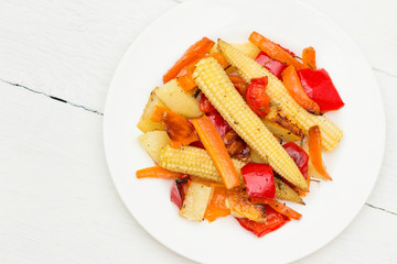 Vegetable casserole. Baked young baby corn and vegetables  on plate.