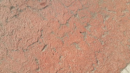 Red colored damaged road or paved pathway with crackes