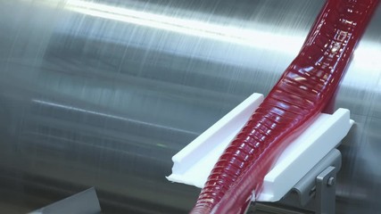 Manufacture of caramel candies. making lollypop. Production of caramel sweets. Lollipops on the production line. Long caramel mass.