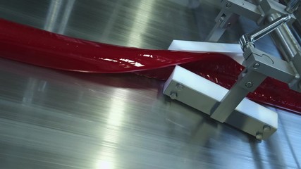 Manufacture of caramel candies. making lollypop. Production of caramel sweets. Lollipops on the production line. Long caramel mass.