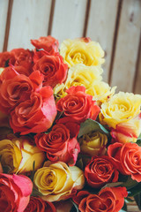 Fototapeta na wymiar Background of orange and yellow roses. Floral background. Orange, yellow, red roses close-up.