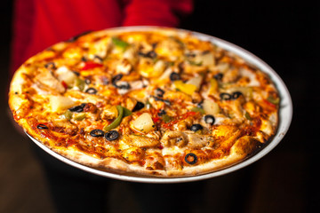 The waiter serves delicious pizza