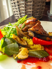 Sliced duck fillet in red berry sauce, salad, bell pepper, zucchini, mashed potatoes