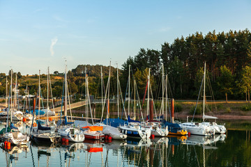 Fototapeta na wymiar Boat station with yachts on Lake Brombach in the evening at sunset