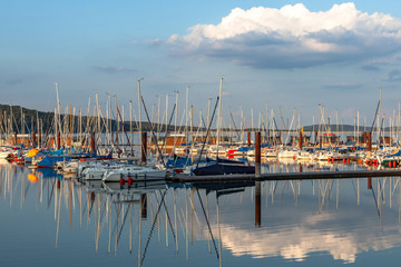 Boat station with yachts on Lake Brombach in the evening at sunset