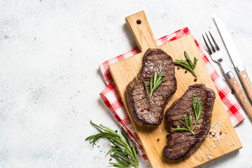 Grilled beef steak on wooden cutting board.