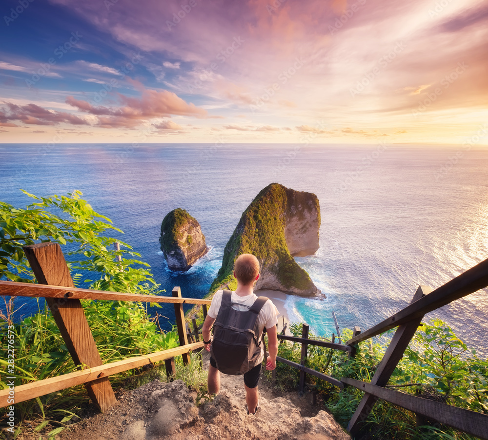 Poster traveler look at the ocean and rocks. travel and active life concept. adventure and travel on bali, 