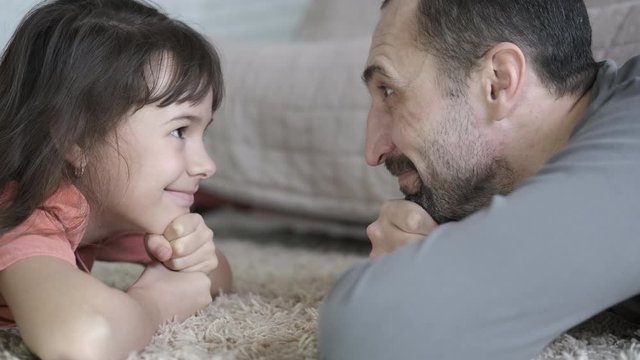 Father and daughter look at each other. Portrait of a happy father and daughter looking at each other.