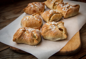 Apple buns. Fresh cakes. Fruit pies lie on a wooden table.