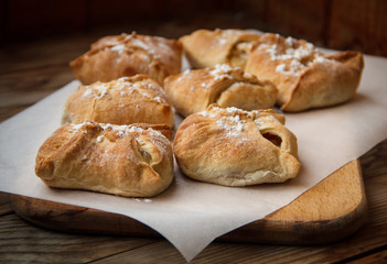 Apple buns. Fresh cakes. Fruit pies lie on a wooden table.