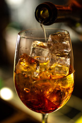 Close-up orange cocktail on the bar, dark blurred background.