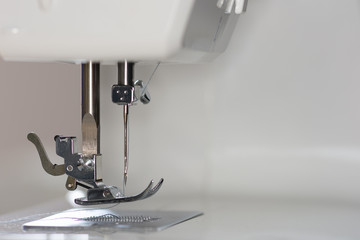 Betriebsbereite Nähmaschine im Detail mit eingelegten Fäden und Spule
