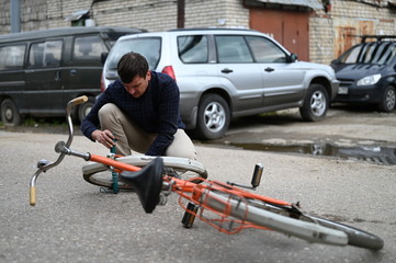 Obraz premium A young man repairing a bicycle on the street