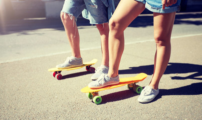 Fototapeta premium summer, extreme sport and people concept - teenage couple riding short modern cruiser skateboards on city street