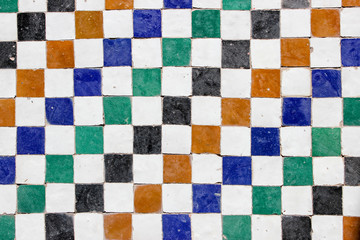 Middle eastern decorative  mosaic tile pattern with white, orange, blue, green and black square tiles