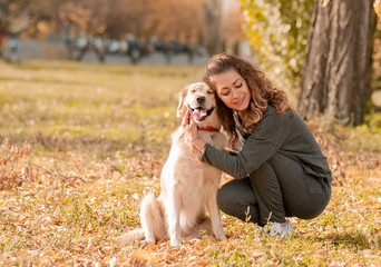 Beautiful smiling woman with cute golden retriever dog