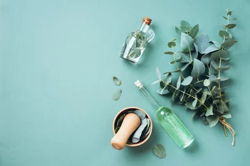 Foto auf Acrylglas Apotheke Schüssel, Flaschen mit ätherischem Eukalyptusöl, Mörser, Haufen frischer Eukalyptuszweige auf grünem Hintergrund. Natürliche Bio-Inhaltsstoffe für Kosmetik, Hautpflege, Körperbehandlung