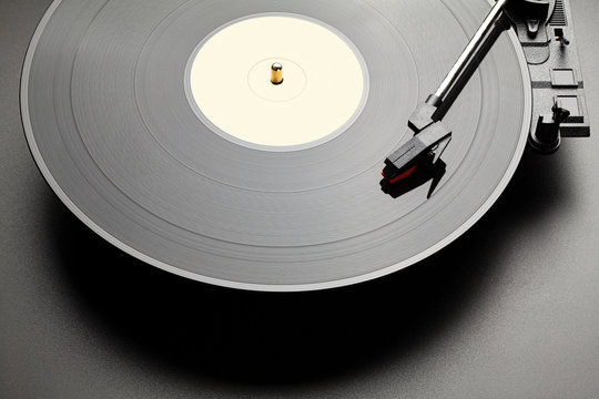 Black vinyl record player on black table background