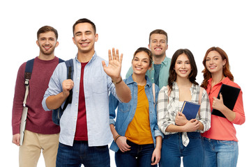 Obraz premium education, high school and people concept - group of smiling students with books waving hands over white background