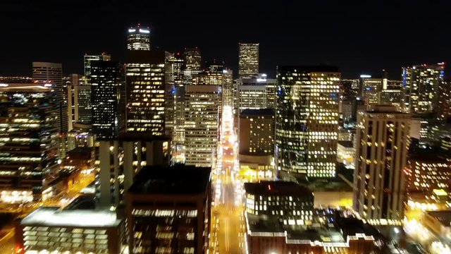 Time Lapse Aerial Forward Along 17th Street in Denver at night with Lit Skyscrapers and Union Station