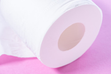 Eco-friendly white toilet paper on a pink background close-up