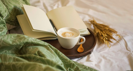 Cozy coffee cup cappuccino with notebook and pen in wooden board , morning bed coffee, vintage coffee cuo, morning coffee still life - 282284127