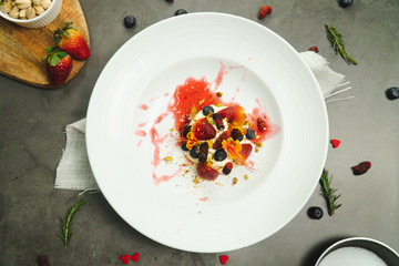 Dessert whip cream topping buy many fruit strawberry blueberry and raspberry set on white plate on cement background