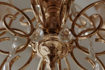 Fototapeta na wymiar Golden chandelier in a classic style with glass pendants on a gray background