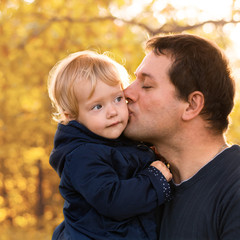 Father and daughter in blue clothes in yellow autumn forest