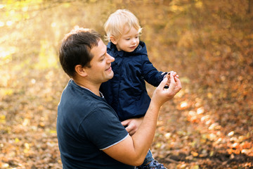 Father and daughter in blue clothes in yellow autumn forest