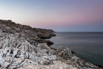 Fototapeta na wymiar Rocky Dramatic Seaside and Mediterranean Sea, Long Exposure Sunrise, Greece