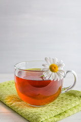 tea in a mug with berries and chamomile on a white background