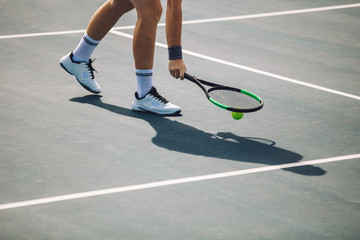 Tennis player picking up the ball