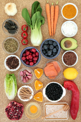 Super food to slow the ageing process concept with fish, fruit, vegetables, seeds, herbs, spice, dairy, kukicha tea, high in antioxidants, anthocyanins, dietary fibre and vitamins. Top view on cork.