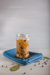 pickled mushrooms in a glass jar on a white background