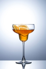 Summer refreshing faintly alcoholic cocktail with orange on a gray gradient background