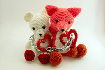 Hearts of 2 Amigurumi dolls a teddy bear and a fox connected by one chain.