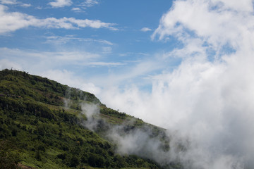 Close-up Fog and cloud mountain valley landscape In the Rainy season with blue Cloud sky background