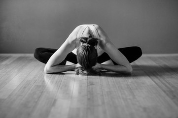 Black and white yoga woman folded butterfly pose. 