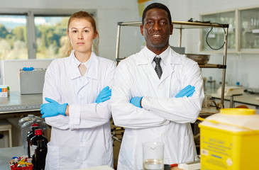 Experienced male and female scientists standing in laboratory