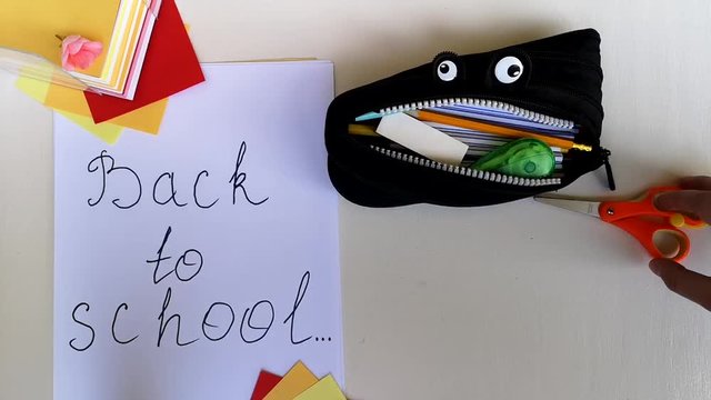 Packing a pencil case back to school, putting in it various school stuff and giving thumb-up. Time-lapse