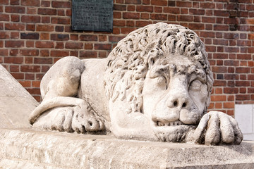 Sculpture of sleeping lion in front of Town Hall at Market Square (Krakow, Poland)