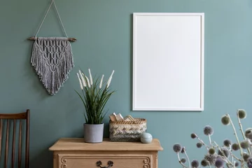 Fotobehang Boho Stylish composition of sitting room interior with white mock up frame, wooden shelf, retro chair, gray macrame, plants, flowers, rattan basket and elegant accessories. Design home decor. Template.   © FollowTheFlow