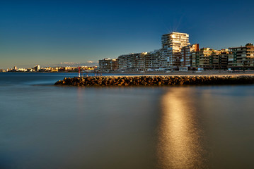 Obraz premium Vivid twilight sunset sky and motion blur of the sea under with long exposure effect.