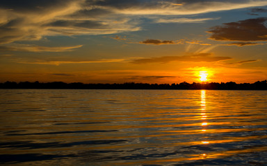 Beautiful Sunset in the sky with sky blue and orange light of the sun through the clouds in the sky, Orange and red dramatic colors over the sea. - Image