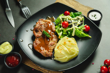 Food shot pork steak with mashed potato and salad